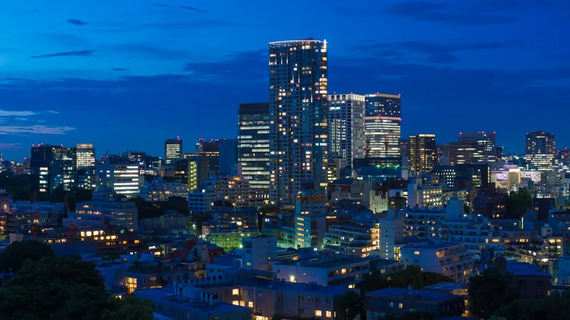 Akasaka, Tokyo at blue hour, with lit office towers rising above low apartment blocks and trees