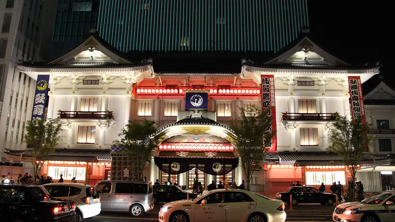 The Kabukiza theatre in Ginza, Tokyo lit up at night, with taxis waiting on the street in front
