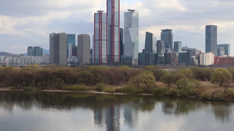 Office towers of Yeouido, the finance district of Seoul, reflected in the Han River under a cloudy sky