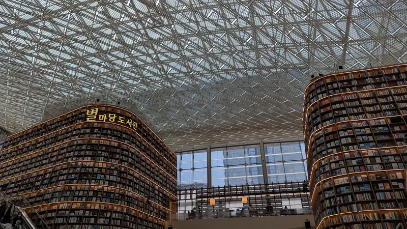 Towering wooden bookshelves under the glass and steel roof of Starfield Library at COEX Mall in Seoul