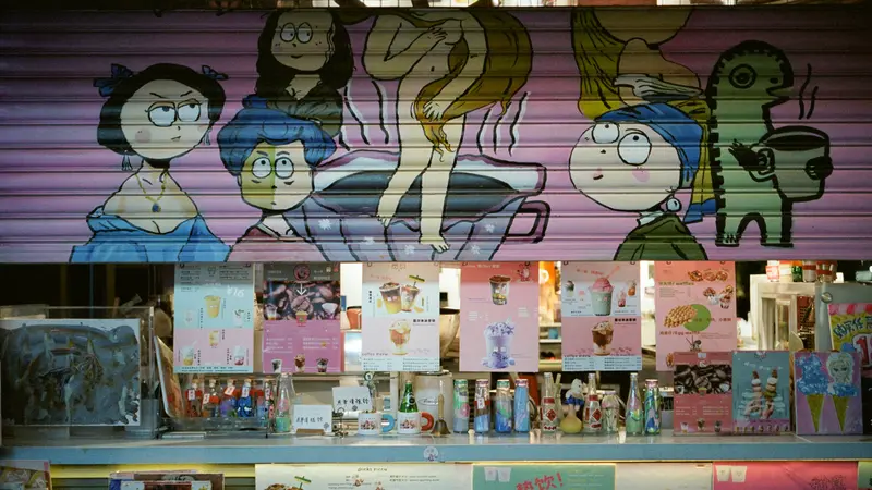 Cartoon characters painted on a pink shop shutter above a window full of drink menus with Chinese text