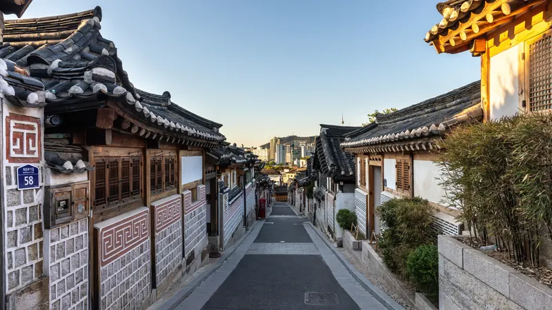 A sloping street lined with traditional hanok houses in Bukchon Hanok Village, Seoul, at sunrise
