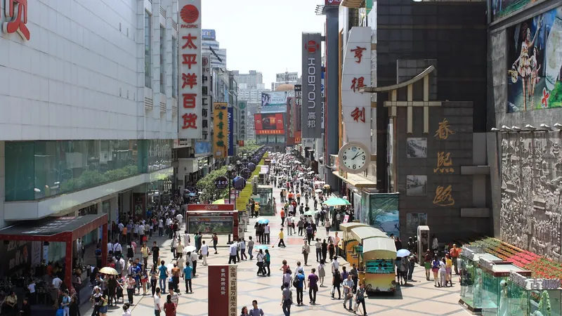 Crowds of shoppers on Chunxi Road, a pedestrian street in Chengdu lined with department stores and Chinese signs