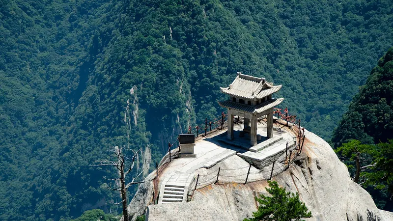 The small Chess Pavilion perched on a bare granite outcrop above forested cliffs on Mount Hua, China