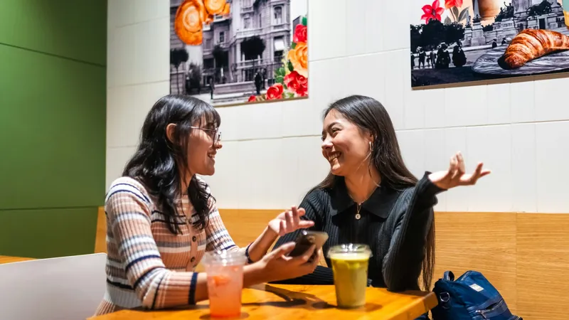 Due ragazze chiacchierano al tavolino di un caffè