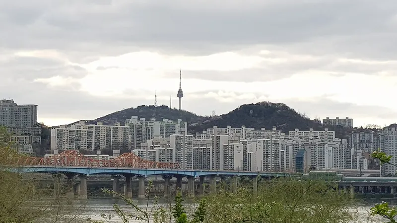 N Seoul Tower on Namsan rising above apartment blocks and Dongho Bridge across the Han River, Seoul